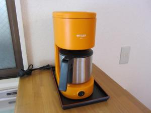 an orange coffee maker sitting on top of a counter at Cheese Cozy Condo in Tokyo