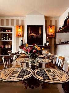 a dining room with a table with flowers on it at Chez Josy in La Bouillie