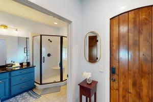 a bathroom with a shower and a blue cabinet at Abruzzi - Villa B in Eatonton 