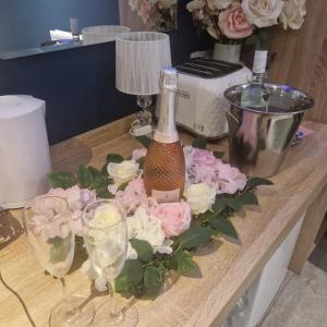 a table with a bottle of champagne and flowers on it at Lenox Bed and Breakfast in Hale