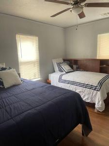 a bedroom with two beds and a ceiling fan at Quiet Comfort minutes from BOK and downtown Tulsa in Tulsa
