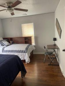 a bedroom with a bed and a table and a chair at Quiet Comfort minutes from BOK and downtown Tulsa in Tulsa