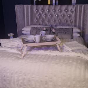 a tray with cups and saucers on a bed at Lenox Bed and Breakfast in Hale