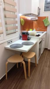 eine Küche mit einer Theke mit zwei Stühlen und einem Tisch in der Unterkunft Modern Studio in Vibrant Kolonaki Area in Athen