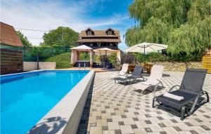 a swimming pool with chairs and a gazebo at Gorgeous Home In Sveti Ivan Zelina With Jacuzzi in Sveti Ivan Zelina