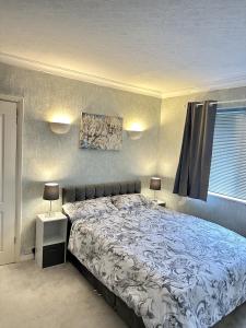 een slaapkamer met een groot bed en 2 nachtkastjes bij Cosy 3 Bedroom House In Birmingham! - Contractors, Business & Corporate Guests Welcome in Holly Lane