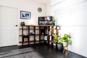 um quarto com uma estante de livros com plantas e uma janela em Beachfront Escape em Port Adelaide