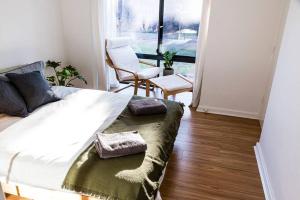 a bedroom with a bed and a chair and a window at Beachfront Escape in Port Adelaide