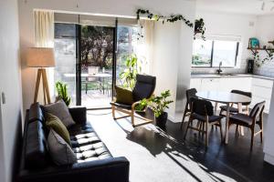 uma sala de estar com um sofá e uma mesa em Beachfront Escape em Port Adelaide