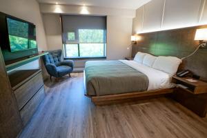 een hotelkamer met een bed en een televisie bij Hôtel & Suites Normandin Lévis in Lévis