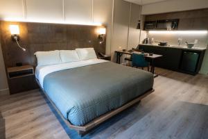 1 dormitorio con 1 cama grande y cocina en Hôtel & Suites Normandin Lévis, en Lévis