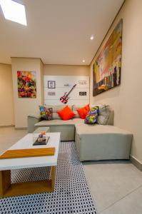uma sala de estar com um sofá e uma mesa em apartamentos Coração Eucarístico em Belo Horizonte