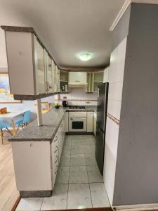 a kitchen with white cabinets and a black refrigerator at Departamento en Playa Brava Iquique 1 dormitorio 1 baño in Iquique