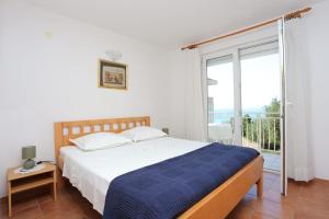 um quarto com uma cama e uma grande janela em Apartments by the sea Baska Voda, Makarska - 300 em Baška Voda