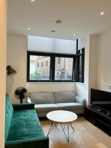 Luxury Modern 1 Bed Apartment في لندن: غرفة معيشة مع أريكة وطاولة