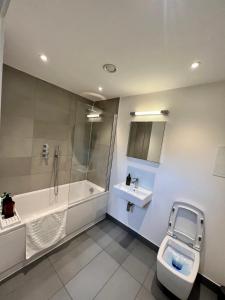 Luxury Modern 1 Bed Apartment في لندن: حمام مع حوض ومرحاض ومغسلة