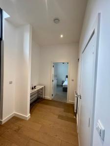 Luxury Modern 1 Bed Apartment في لندن: ممر مع باب يؤدي إلى غرفة النوم