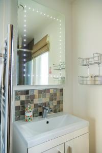 W łazience znajduje się umywalka i lustro. w obiekcie Boutique Country House Aldergrove w mieście Crumlin