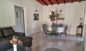 a living room with a couch and a table and chairs at akaixora -ixora in Le Moule +7 photos