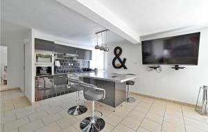 cocina con mesa y TV en la pared en 2 Bedroom Cozy Home In Sarrians, en Sarrians