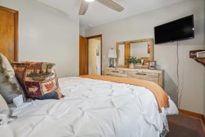 Schlafzimmer mit einem Bett und einem Flachbild-TV in der Unterkunft Utica Vacation Home about 12 Mi to Denison University! 