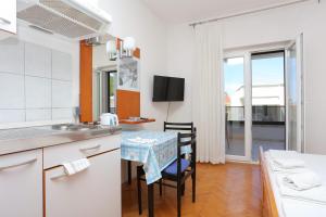 a kitchen with a table with chairs and a sink at Apartments with parking space Baska Voda, Makarska - 6773 in Baška Voda