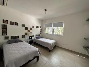 a bedroom with two beds and a window at Zen Home in Tulum