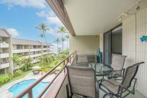 balcón con mesa de cristal y sillas y piscina en White Sands Village, Gorgeous 2BR, Top/Front Bldg en Kailua-Kona