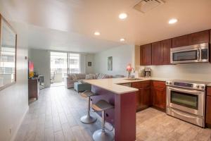 a kitchen with a counter and a living room at White Sands Village, Gorgeous 2BR, Top/Front Bldg in Kailua-Kona