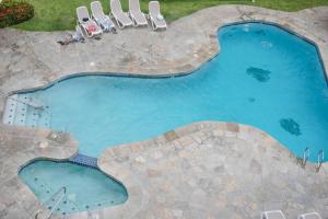 an overhead view of a swimming pool with chairs in a yard at White Sands Village, Gorgeous 2BR, Top/Front Bldg in Kailua-Kona
