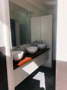 Baño con 3 lavabos y espejo en Andino BnB en Salta