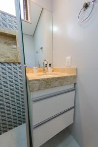 W łazience znajduje się umywalka i prysznic. w obiekcie apartamentos Coração Eucarístico w mieście Belo Horizonte