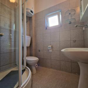 a bathroom with a sink and a toilet and a window at Apartmani Vlahović in Sutomore +47 photos