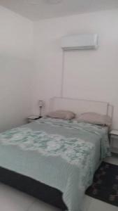 a bed in a white room with a window at Departamento en Villa Elisa. in Villa Elisa