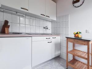 a kitchen with white cabinets and a table with fruit on it at Apartments by the sea Viganj, Peljesac - 16259 in Kučište