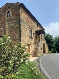 un vecchio edificio in mattoni con scala accanto a una strada di Casa Zeno a Volterra