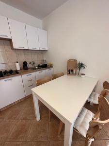 biała kuchnia z białym stołem i krzesłami w obiekcie Relax and Unwind: Family-Friendly House near Zadar in Zagrad w mieście Zadar