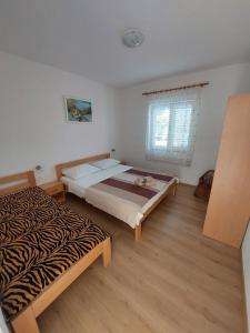 1 dormitorio con 2 camas y ventana en Family Room Drace 4550a, en Drače