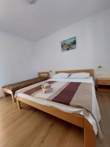 1 dormitorio con 1 cama grande y suelo de madera en Family Room Drace 4550a, en Drače