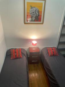 1 dormitorio con 2 camas y mesa con lámpara en Andino BnB en Salta