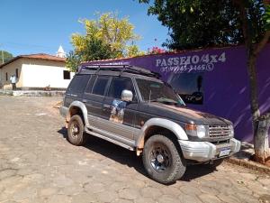 a black suv parked in front of a purple wall at Canto do Rio Pousada in Vargem Bonita