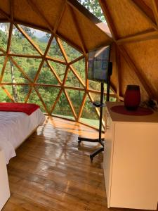 a room with a bed and a desk in a tent at Magic Elf Glamping in Mindo