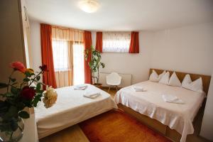 a bedroom with two beds and a vase of flowers at Charming Villa in a Private Mountain Resort in Braşov
