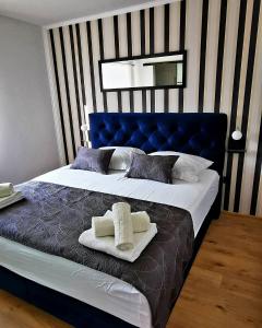 - une chambre avec un lit bleu et des serviettes dans l'établissement Family friendly house with a swimming pool Kastel Sucurac, Kastela - 21570, à Kaštel Sućurac