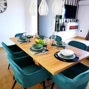 uma mesa de madeira com cadeiras verdes e uma sala de jantar em Family friendly house with a swimming pool Kastel Sucurac, Kastela - 21570 em Kaštel Sućurac