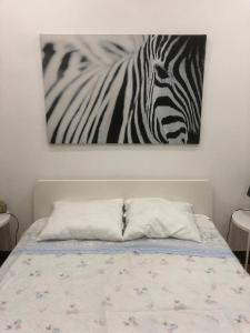 a painting of a zebra is hanging above a bed at Grandma`s house in Lisbon in Odivelas