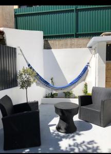 un patio con sillas, una mesa y una hamaca en Grandma`s house in Lisbon, en Odivelas