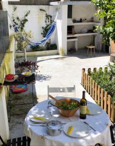 una mesa con un tazón de comida y una botella de vino en Grandma`s house in Lisbon, en Odivelas