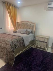 een slaapkamer met een bed, een dressoir en een raam bij Cozy Airport Penthouse,Accra in Accra