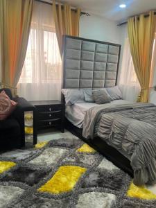 een slaapkamer met een groot bed en een tapijt bij Cozy Airport Penthouse,Accra in Accra